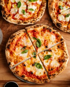 Classic Pizza Margherita – a true Italian favourite with rich tomato sauce, fior di latte mozzarella, and fresh basil, baked to perfection at Sicily Restaurant.