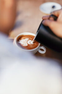 Close-up of a beautifully crafted latte with intricate latte art, a perfect way to start the day or unwind at Sicily Restaurant.