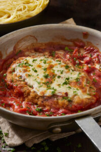 Pollo alla Pizzaiola – tender chicken in a rich tomato sauce with garlic, oregano, and melted cheese, a comforting Italian classic from Sicily Restaurant’s à la carte menu.