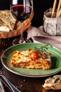 Lasagne dish and glass of red wine. A traditional easter classic in central and southern italy